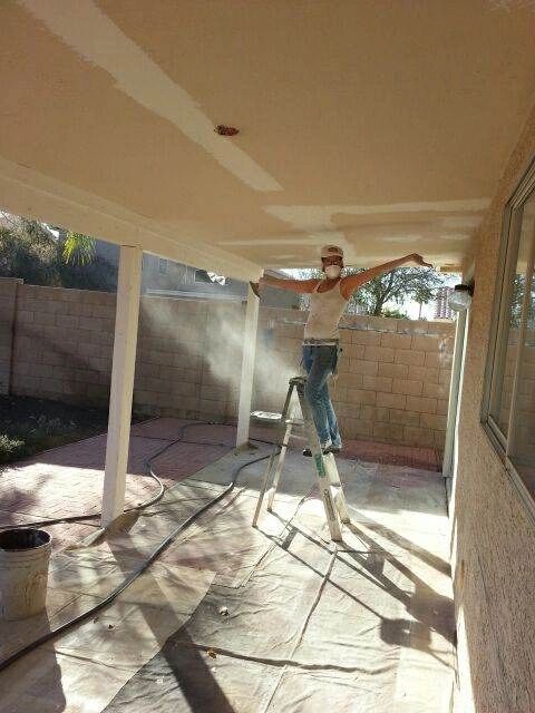 Toni working on drywall ceiling